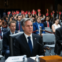 Protesters calling for a ceasefire in Gaza raise their hands covered in red paint as Secretary of State Antony Blinken testifies at a Senate appropriations committee hearing to ask for billions more in military aid for Israel, on Capitol Hill, in Washington DC, 31 October. Graeme Sloan SIPA USA